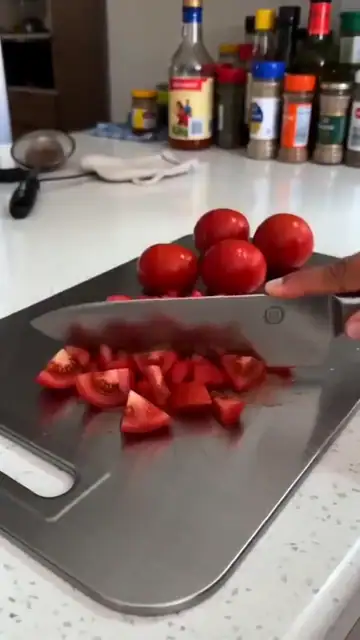 Picando tomate y carne sobre la tabla de titanio